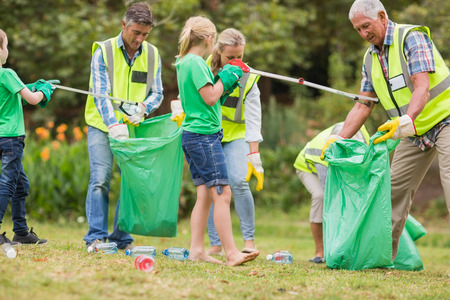Happy family collecting rubbish on a sunny day