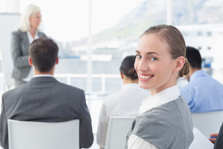 Businesswoman looking at camera during meeting in meeting roomの写真素材
