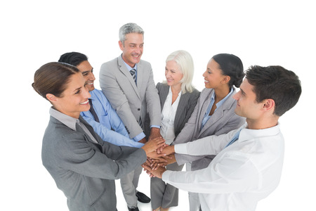 Portrait of happy executives holding hands together in the office