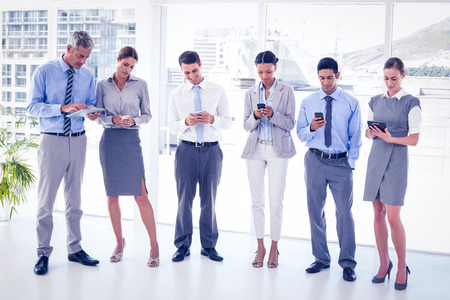 Business people using their phone in officeの写真素材