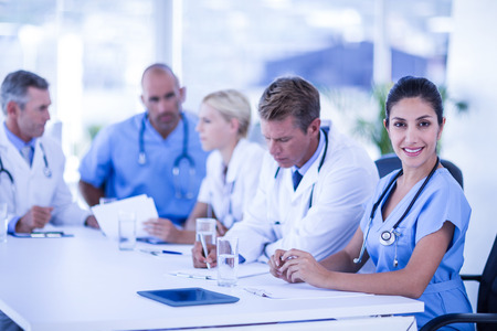 Nurse smiling at camera during meeting at the hospitalの写真素材