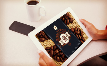 Woman using tablet pc  against fair trade label on coffee