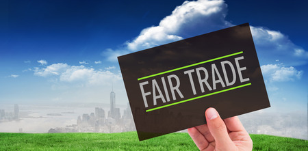 Hand showing card against blue sky over cityの写真素材