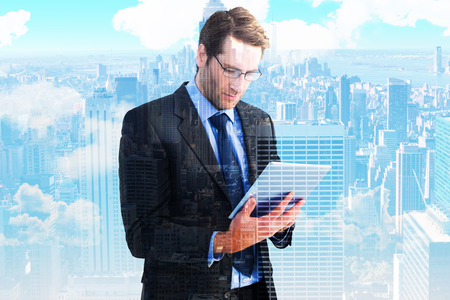 Businessman using a tablet computer against city skylineの写真素材