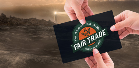 Hand showing card against stormy sea with lighthouseの写真素材