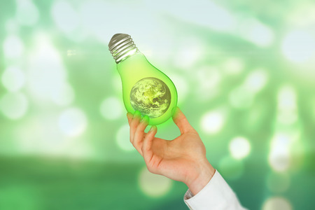 Hand presenting against light circles on green backgroundの写真素材