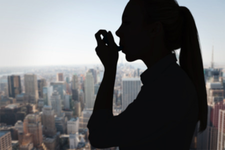 Beautiful blonde using an asthma inhaler against new yorkの写真素材