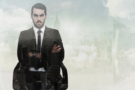 Serious businessman sitting with arms crossed against new york
