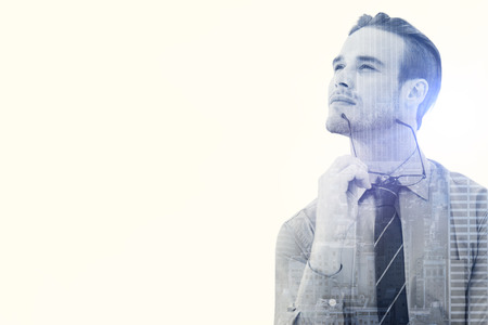 Businessman thinking against city skylineの写真素材