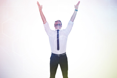 Smiling businessman cheering with his hands up against digitally generated server room with towersの写真素材