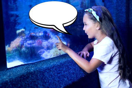 Speech bubble against cute girl looking at fish tank