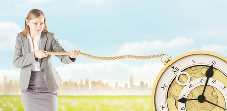 Businesswoman pulling a rope against city on the horizonの写真素材