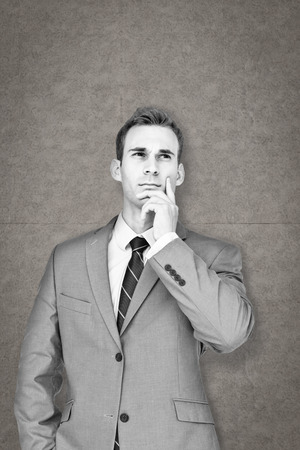 Businessman thinking against grey backgroundの写真素材