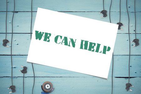 The word we can help and white card against plugs on wooden backgroundの写真素材