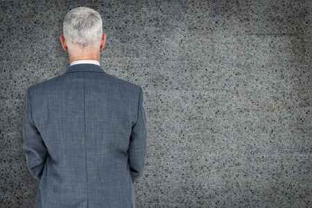 Businessman standing against grey backgroundの写真素材