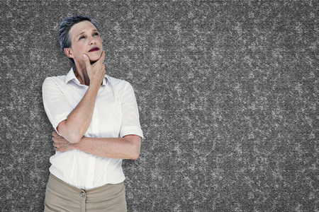 Businesswoman thinking against grey backgroundの写真素材