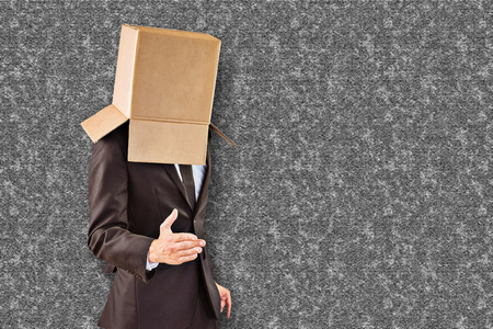 Anonymous businessman offering his hand against grey backgroundの写真素材