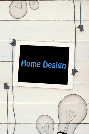 The word home design against tablet and plugs on wooden backgroundの写真素材