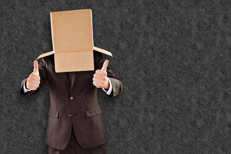 Anonymous businessman with thumbs up against grey backgroundの写真素材