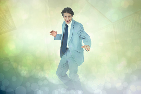 Smiling businessman against yellow abstract light spot designの写真素材