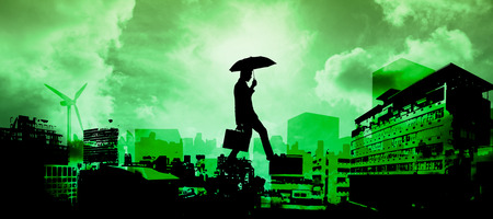 Businessman stepping against green sky over cityの写真素材