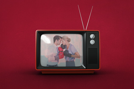 Business people wearing and boxing red gloves against red backgroundの写真素材