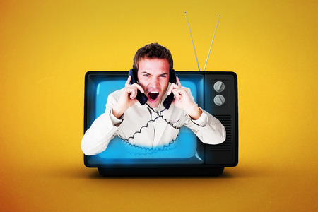 Confident businessman having a phone call against orange backgroundの写真素材