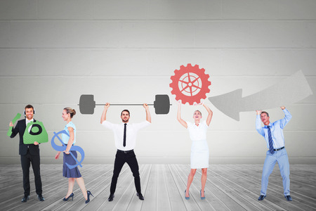 Business people holding icons against grey roomの写真素材