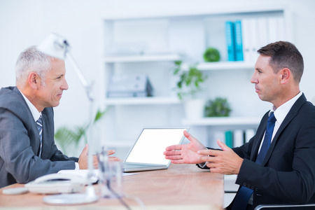 Two serious businessmen speaking and working at the officeの写真素材