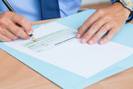 Businessman writing a contrat before signing it in the office