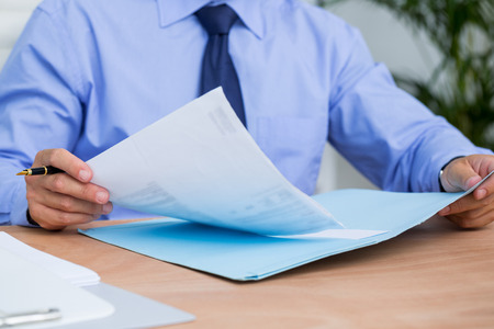 Businessman reading a contract before signing it in the officeの写真素材