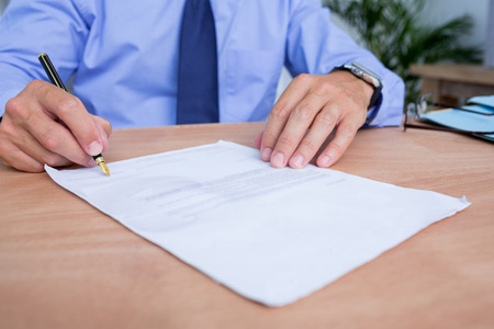 Close up view of businessman signing a contract in the office