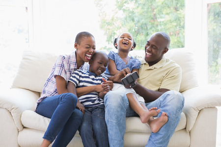 Happy smiling family on the couch in the living roomの写真素材