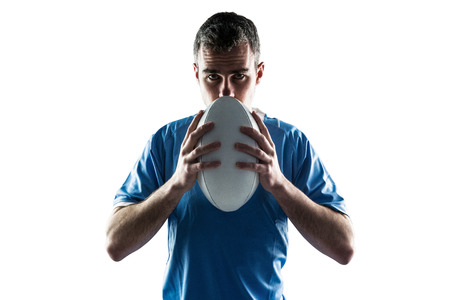 Portrait of a serious rugby player holding a rugby ballの写真素材