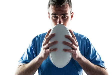 Portrait of a serious rugby player holding a rugby ballの写真素材