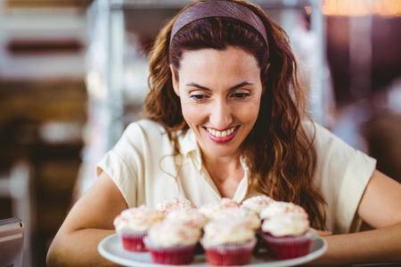 Pretty brunette looking at cakes in the bakery storeの写真素材