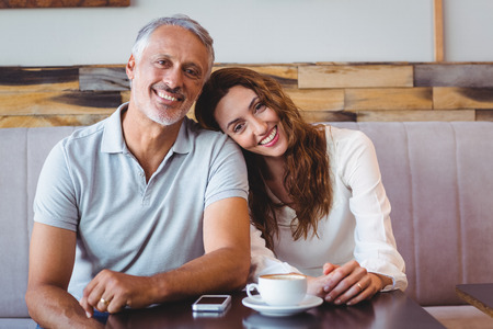 Cute couple drinking coffee in the cafeの写真素材