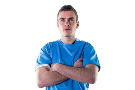 Serious rugby player with arms crossed on a white background