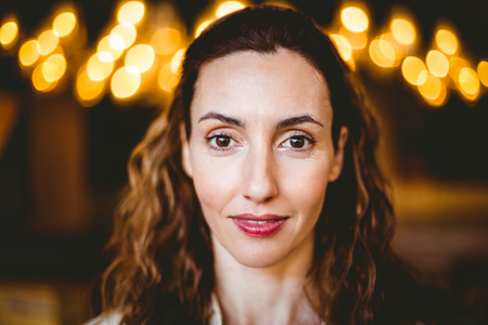 Close up of calm brunette looking at camera at the bakery storeの写真素材