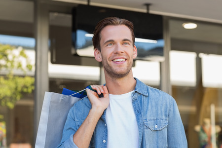 A smiling man with shopping bags at the mallの写真素材