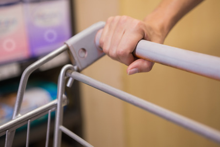 Hand of woman putting on trolley in officeの写真素材