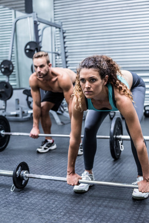 Side view of a muscular couple about to lift weights