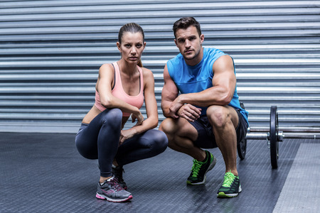 Portrait of a muscular couple in a squatting position