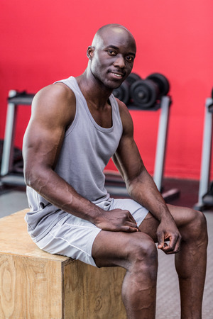 Portrait of muscular man sitting on a wooden boxの写真素材