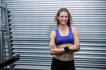 Portrait of muscular woman with arms crossed in crossfit gym