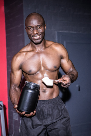 Young Bodybuilder filling his Bottle in the crossfit gymの写真素材