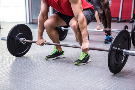 Three young Bodybuilders doing weightlifting ini the crossfit gymの写真素材