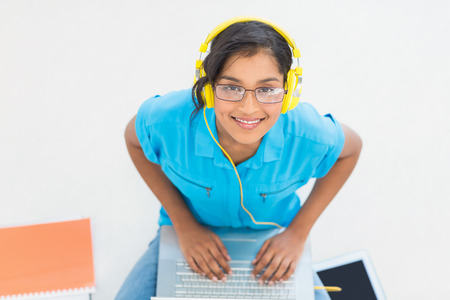 Casual businesswoman listening to music on the floorの写真素材