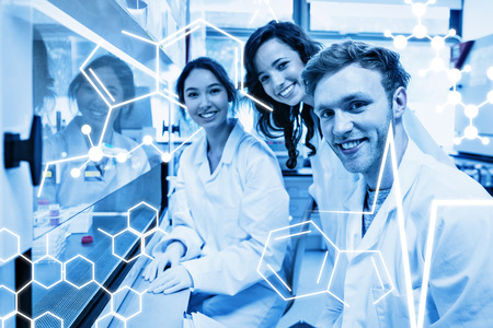 Science graphic against science students using pipette in the labの写真素材