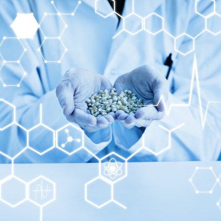 Science graphic against student in lab coat holding grainの写真素材